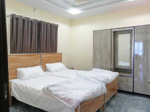 Ghora GaliにあるNavid's Holiday Resort and Hotel, Murreeのベッドルーム1室(ツインベッド2台、窓付)