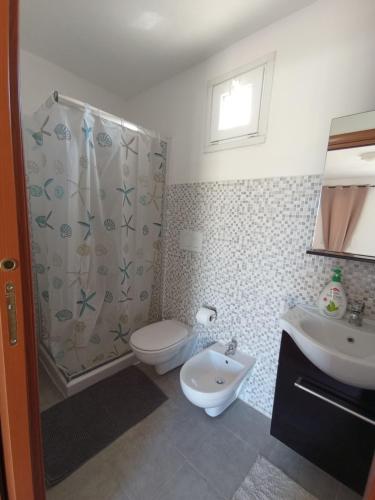 uma casa de banho com um WC, um chuveiro e um lavatório. em Stanze Agli Ulivi em Porto Cesareo