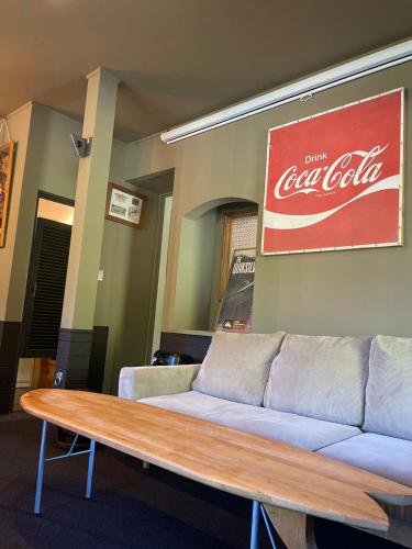 a couch with a cocacola sign on a wall at 伊豆 白浜 ゲストハウス茉心 in Shimoda