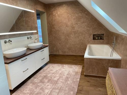 a bathroom with two sinks and a bath tub at Excl. Maisonette Ferienwohnung in Coesfeld