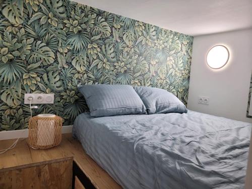une chambre avec un lit et une peinture murale dans l'établissement Studio des Halles, au Havre