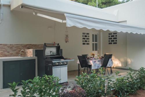 une terrasse avec une cuisinière et une table avec des chaises dans l'établissement Sea Zen Guesthouse, à Rafína