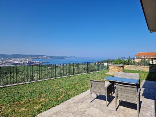 a table and chairs on a patio with a view of the ocean at Villa ELM in Ankaran