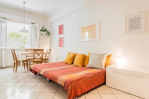 1 Schlafzimmer mit einem Bett und einem Esszimmer in der Unterkunft Beautiful apt with green veranda - Heart of Athens in Athen