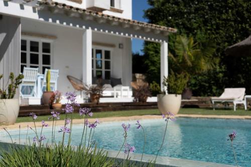 a house with a swimming pool and purple flowers at Casa La Siesta in Vejer de la Frontera