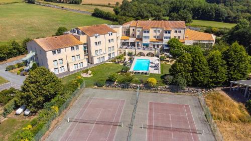 een luchtzicht op een herenhuis met een tennisbaan bij Logis Hôtel Restaurant Aloe in Les Herbiers