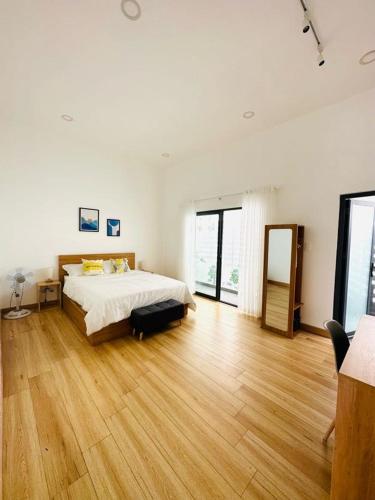 a large white bedroom with a bed and wooden floors at Sol Valley - Hideaway Station in Blao Srê