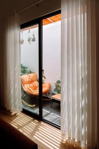 a sliding glass door with a chair on a balcony at Sol Valley - Hideaway Station in Blao Srê
