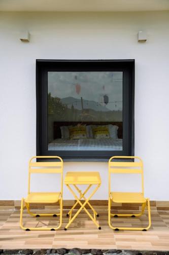 two yellow chairs sitting in front of a fireplace at Sol Valley - Hideaway Station in Blao Srê