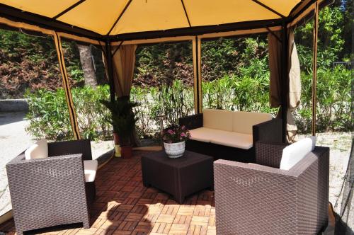 a gazebo with chairs and a couch and a table at Esedra Hotel in Rimini