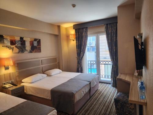 a hotel room with two beds and a balcony at Nanda Hotel in Istanbul