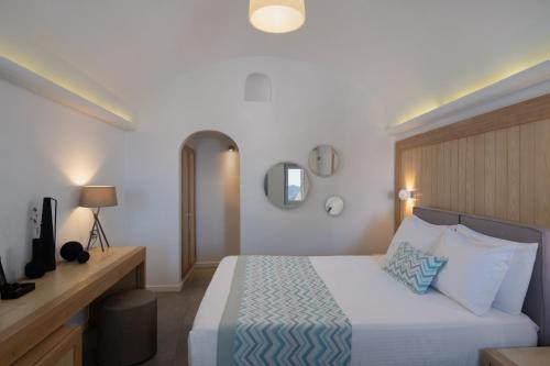 a hotel room with a bed and a mirror at Volcano View by Caldera Collection in Fira
