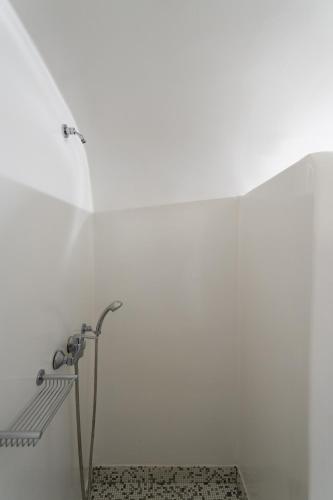 a shower in a bathroom with a white wall at Volcano View by Caldera Collection in Fira