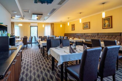 Hotel Castello & Thermal Spa Siklós في سيكلوس: مطعم فيه طاولات وكراسي في الغرفة