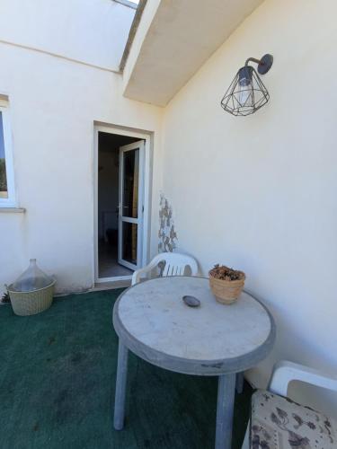 Habitación blanca con mesa y sillas en Stanze Agli Ulivi, en Porto Cesareo
