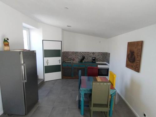 een keuken met een koelkast en een tafel. bij Cabaña MEXICANA in Fougeré