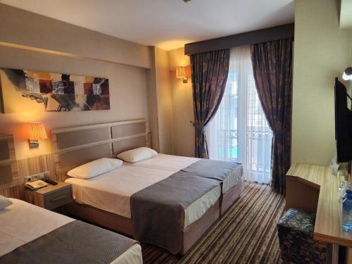 a hotel room with two beds and a window at Nanda Hotel in Istanbul
