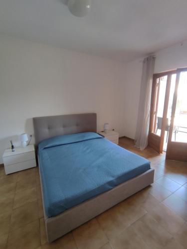 Un dormitorio con una cama con una manta azul. en La Piazzetta, en Nettuno