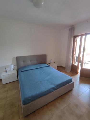 a bedroom with a bed with a blue blanket on it at La Piazzetta in Nettuno