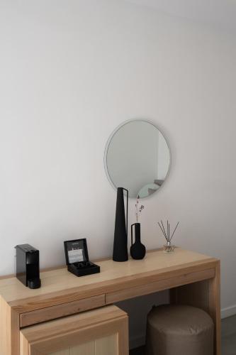 a desk with a circular mirror and a chair at Volcano View by Caldera Collection in Fira