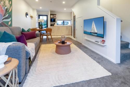 a living room with a couch and a tv at Modern Comforts 2 bed 2 bath Inner City in Christchurch