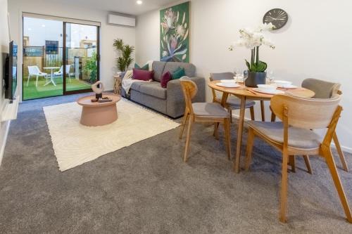 a living room with a table and a couch at Modern Comforts 2 bed 2 bath Inner City in Christchurch