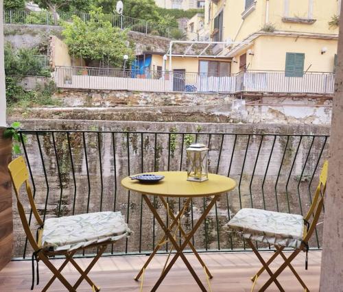 een gele tafel en 2 stoelen op een balkon bij Piccolo appartamento di charme in Napels