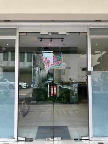 a store window with a reflection of a car in it at Swing & Pillows @ Malabar in George Town