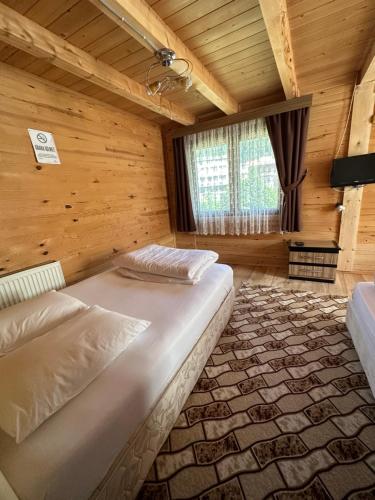 a bedroom with a large bed in a wooden room at Abduloğlu Butik Otel in Çamlıhemşin