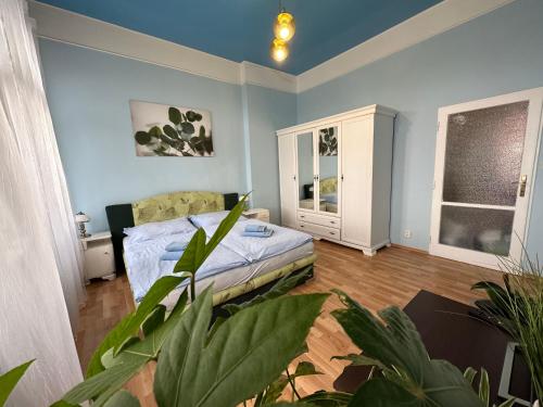 - une chambre avec un lit et une plante en pot dans l'établissement Svahova 986/6, à Karlovy Vary