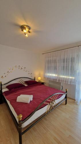 - une chambre avec un grand lit et une couverture rouge dans l'établissement Apartman SKY 4, à Brčko