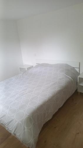 ein weißes Bett in einem weißen Zimmer mit einer weißen Matratze in der Unterkunft Maison à proximité de la ville avec jardin clôturé in Casseneuil