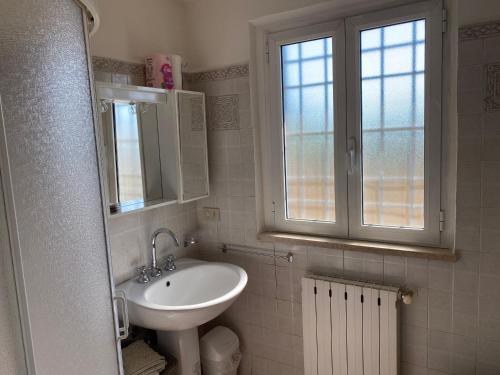 La salle de bains est pourvue d'un lavabo et d'une fenêtre. dans l'établissement Casa versilia, à Mommio