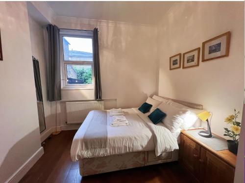 a small bedroom with a bed and a window at Lovely 2 Bedroom Garden Flat in London in London