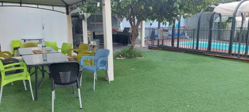a patio with a table and chairs and a pool at וילה בת גליל יסוד המעלה in Yesod Hamaala