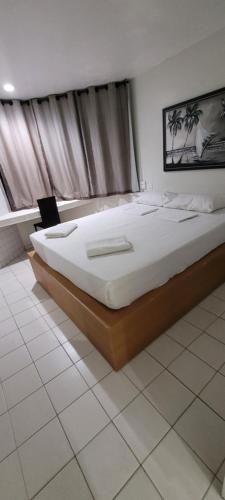 ein Schlafzimmer mit einem großen Bett in einem Zimmer in der Unterkunft Hotel Victory Business Flat Beira Mar Tambaú in João Pessoa