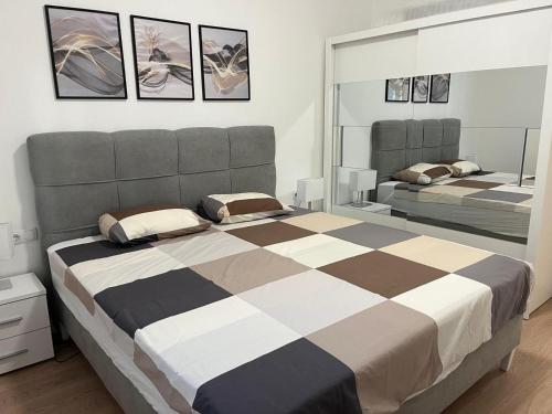 1 Schlafzimmer mit 2 Betten und 2 Spiegeln in der Unterkunft Olive center apartment in Trebinje