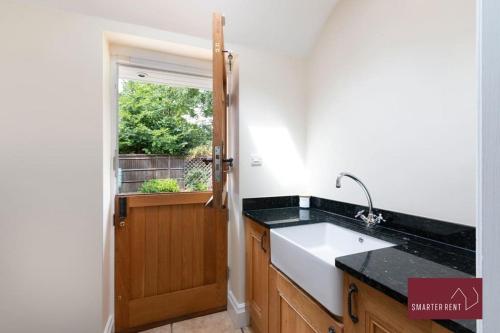 a kitchen with a sink and a window at Farnborough - Grand 4 Bed Home in Cove