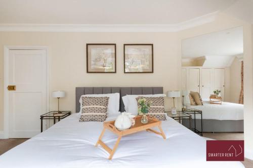 Farnborough - Grand 4 Bed Home في Cove: غرفة نوم بسريرين وطاولة على سرير