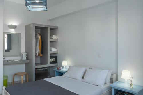 a bedroom with a bed and two tables and a mirror at Villa Valvis in Perissa