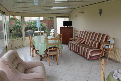 un salon avec une table et un canapé dans l'établissement CHAMBRES D'HÔTES chez réjane, à Crasville
