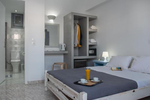 a bedroom with a bed with a tray with drinks on it at Villa Valvis in Perissa