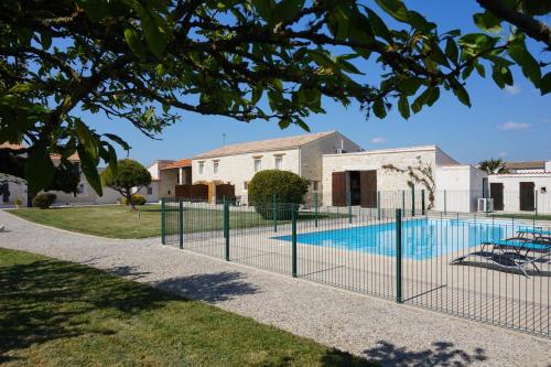 une clôture autour d'une piscine en face d'une maison dans l'établissement Appartement La Rochelle, à Sainte-Soulle