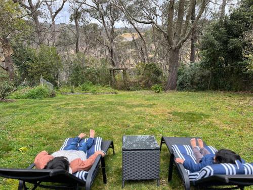 zwei Leute, die auf Gartenstühlen im Garten liegen in der Unterkunft Blissful Mountain Stay in Katoomba
