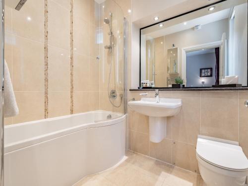 ein Badezimmer mit einem Waschbecken, einem WC und einem Spiegel in der Unterkunft Apartment 14, Hazelwood Hall in Silverdale