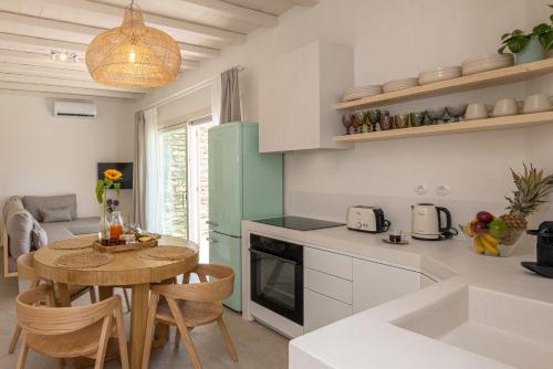 a kitchen and dining room with a table and chairs at Velouchi Hideout Residence in Tinos