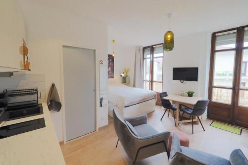 une chambre d'hôtel avec un lit, une table et des chaises dans l'établissement Studio refait à neuf en hypercentre avec balcon, à Aix-les-Bains