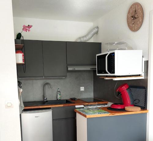une cuisine avec un micro-ondes et un plan de travail dans l'établissement Bel Appartement face au paleospace, à Villers-sur-Mer