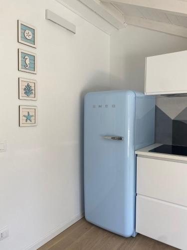a kitchen with a blue refrigerator in a room at Diano Design&Suite Azur in Diano Marina