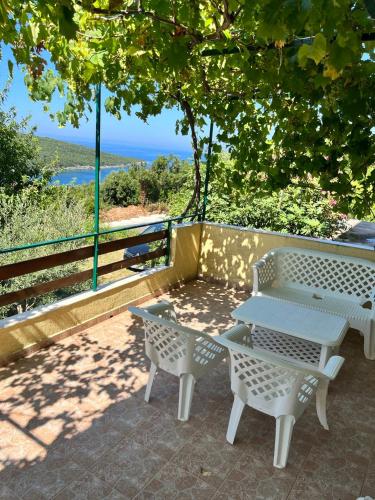 - une table de pique-nique et des chaises sur une terrasse donnant sur l'océan dans l'établissement Apartman Perić, à Bigovo